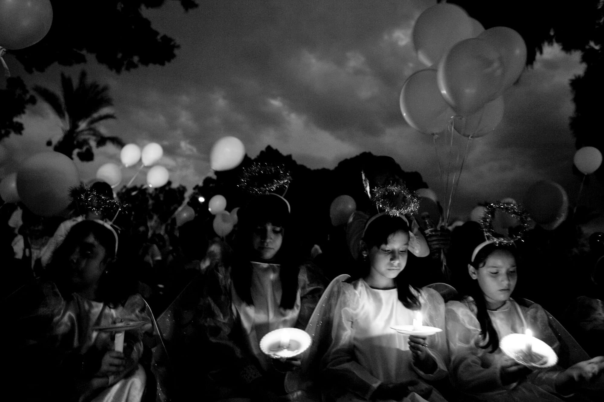 A black-and-white photograph by Carlos Javier Ortiz of demonstrators outside of the Arizona State Capitol with lit candles