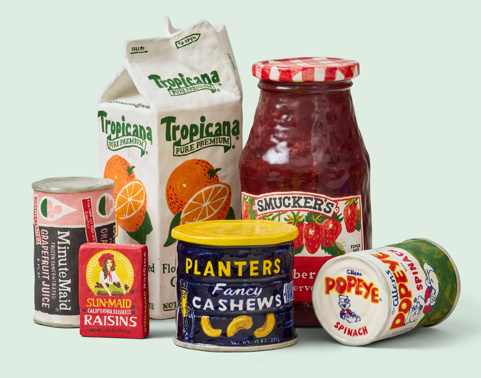 a collection of ceramic food items on a pale green backdrop