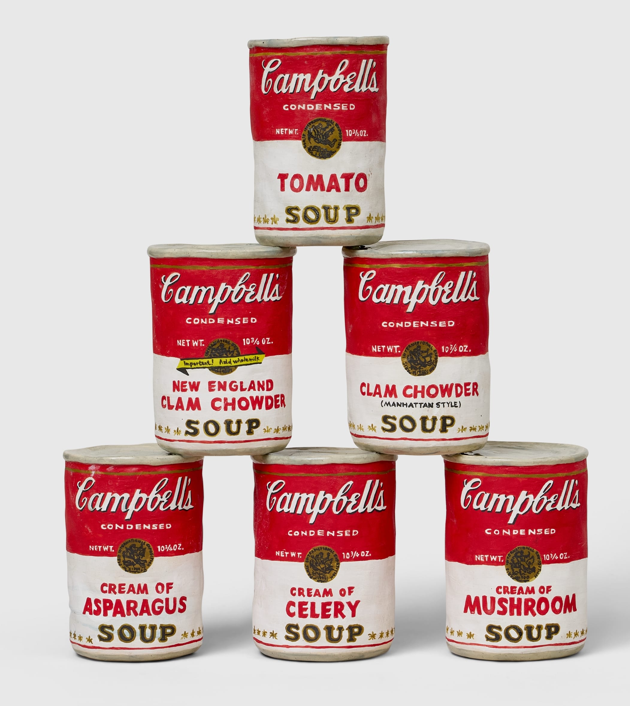 six ceramic cans of campbell's soup stacked in a pyramid