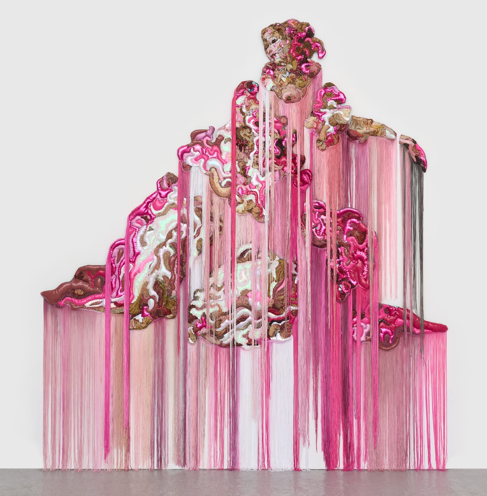 a monumental, abstract wall installation by Anne von Freyburg that appears to be cascading in pink and brown hues. a face appears at the top