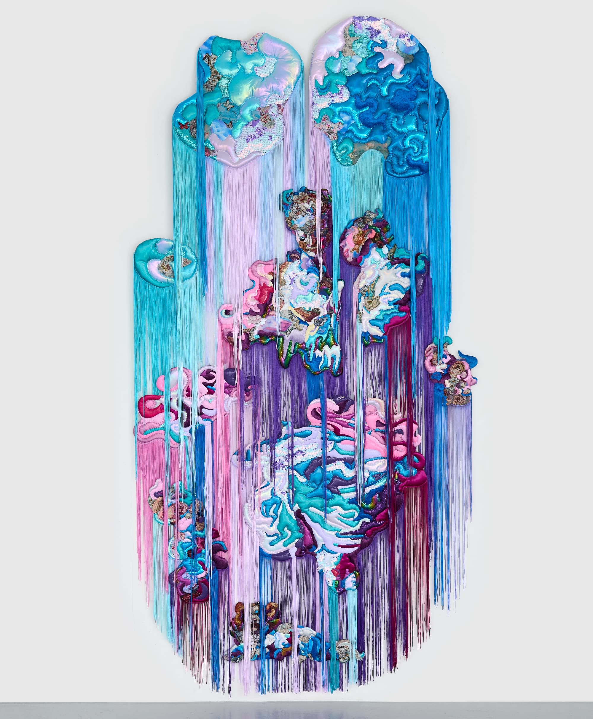 a monumental, abstract wall installation by Anne von Freyburg that appears to be cascading in purple, teal, and pink hues