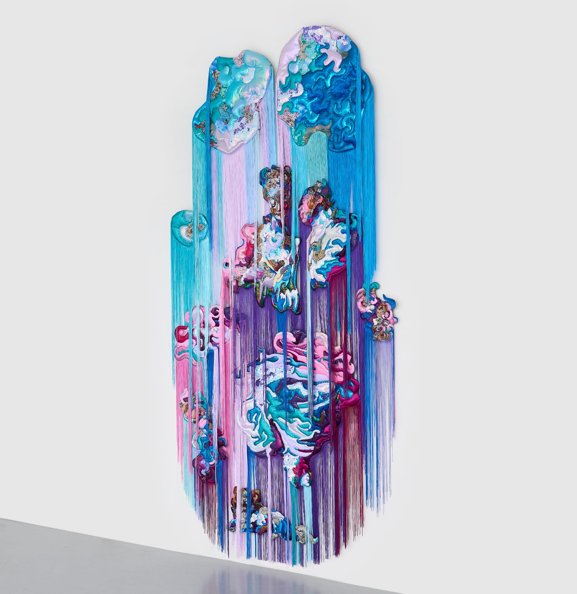 a monumental, abstract wall installation by Anne von Freyburg that appears to be cascading in purple, teal, and pink hues