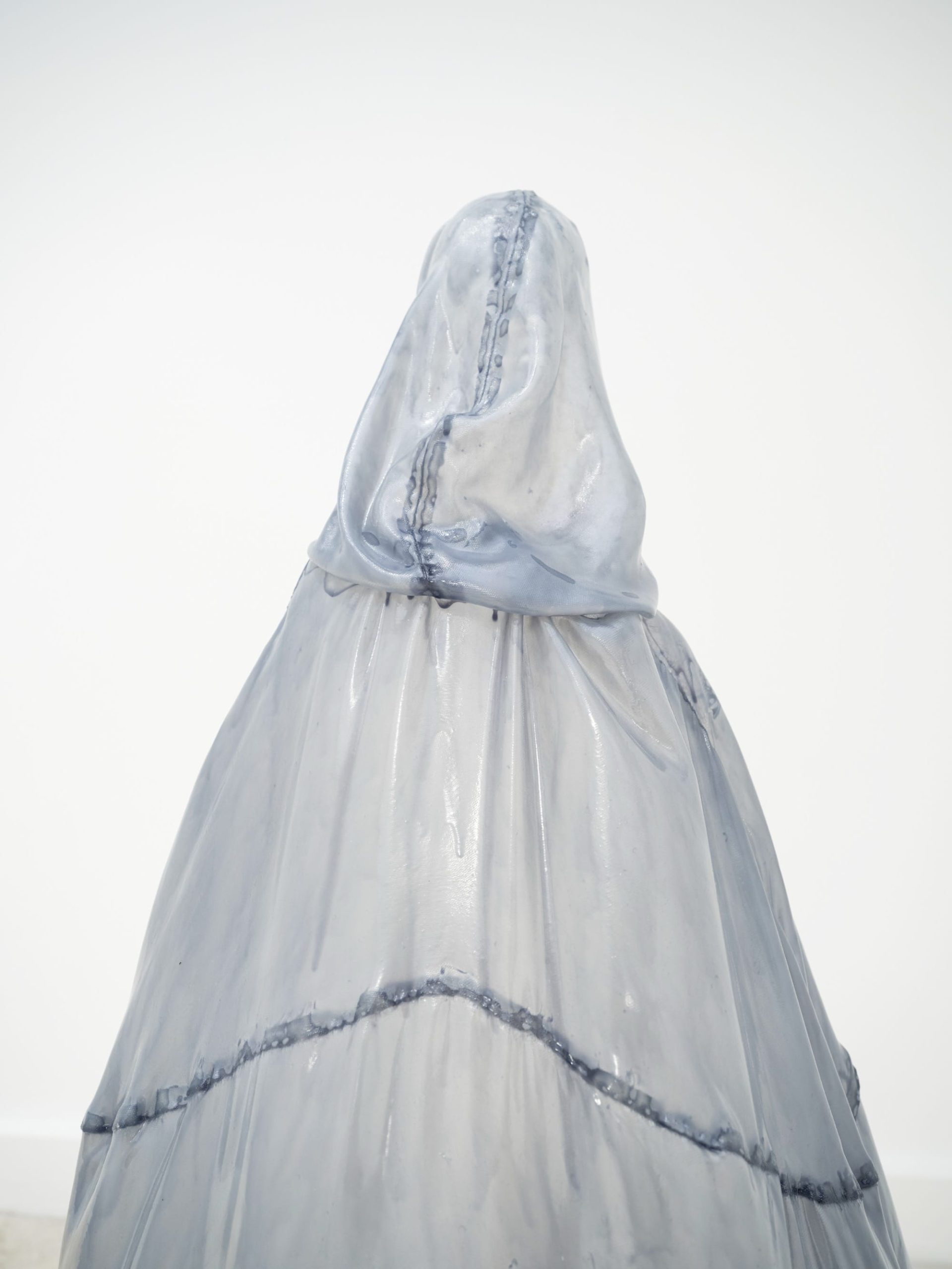A stiff pale blue fiberglass victorian style dress by Brandon Morris that stand without wearers in the middle of a gallery