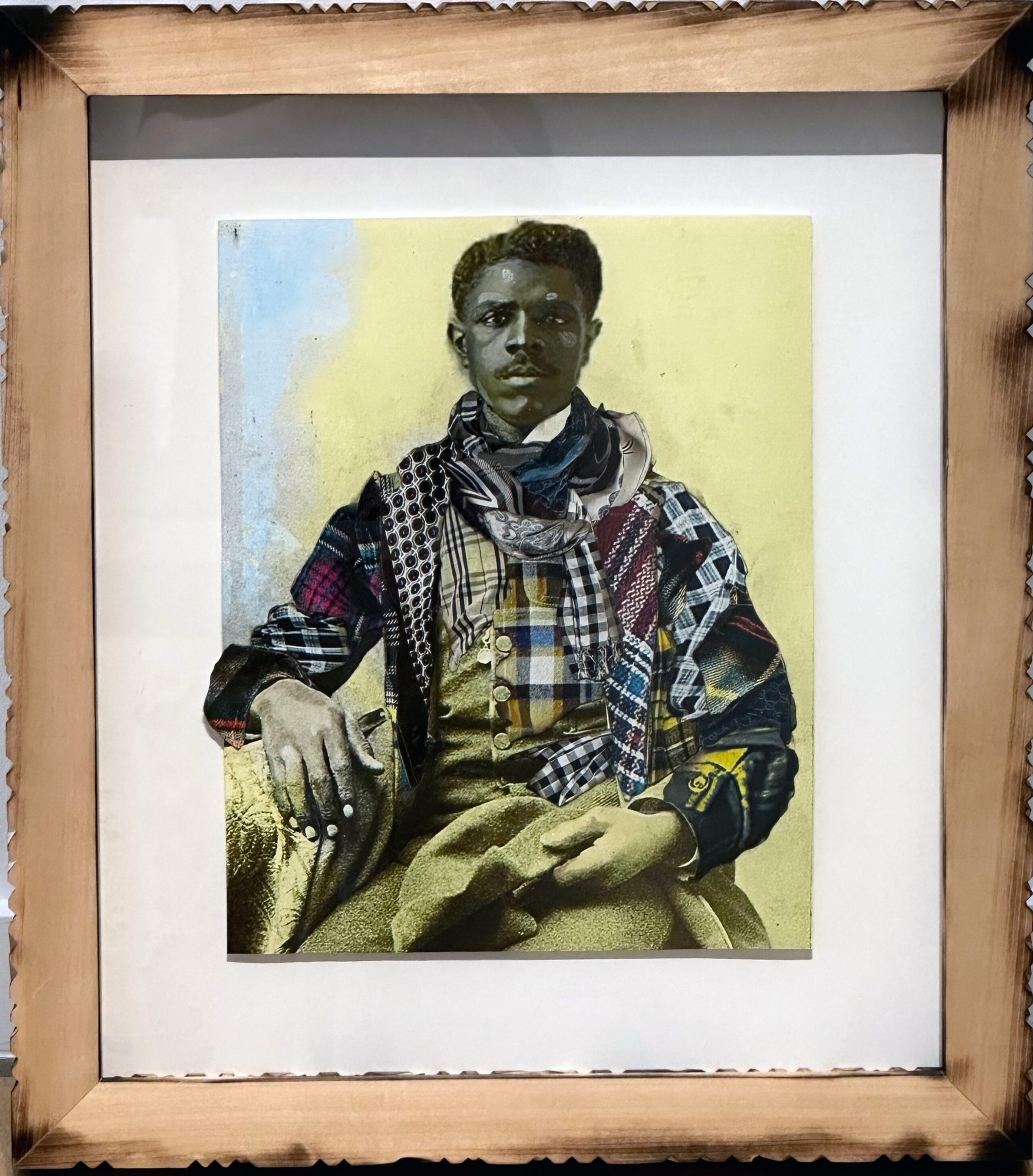 a framed portrait by Stan Squirewell, from an old photograph, of a seated Black man with colorful, patterned fabrics collaged onto the image