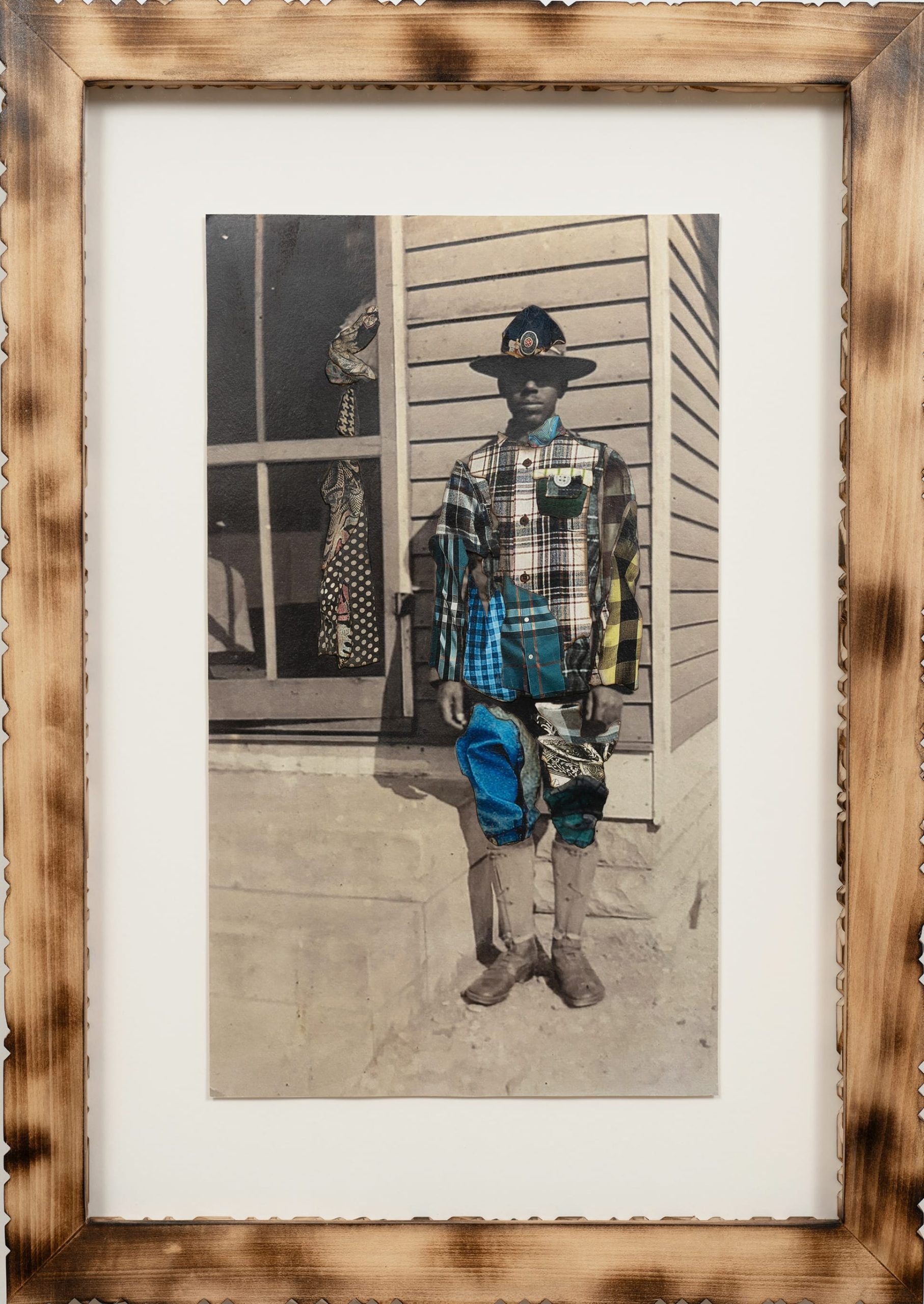 a framed portrait by Stan Squirewell, from an old photograph, of a Black man wearing a hat, with colorful, patterned fabrics collaged onto the image